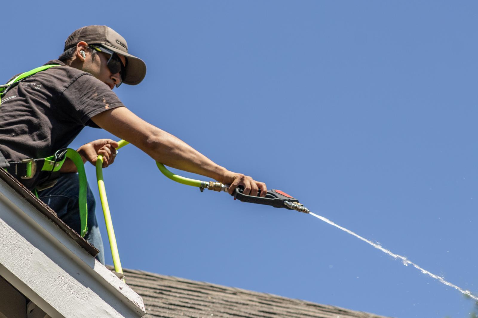 Valley Lights crew rinsing a roof and gutters on a sunny day