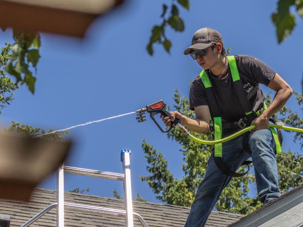 Spraying down a house exterior from the roof edge