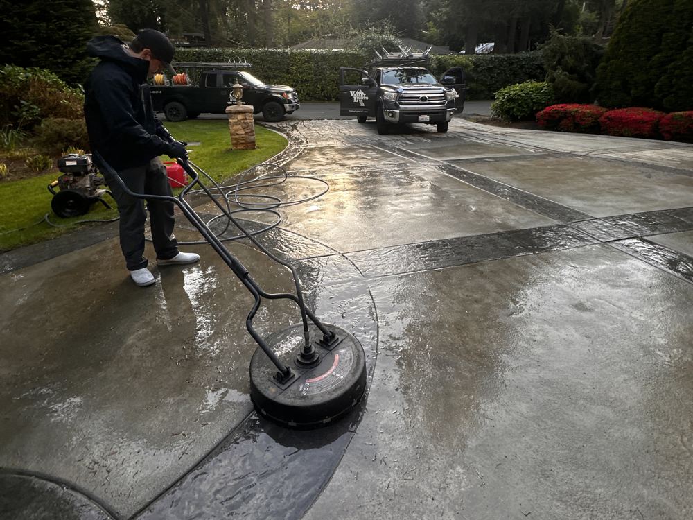 Surface-cleaning a concrete driveway with the Valley Lights trucks behind