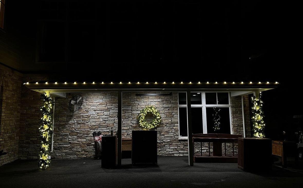 Commercial patio with roofline lights, garland and wreath
