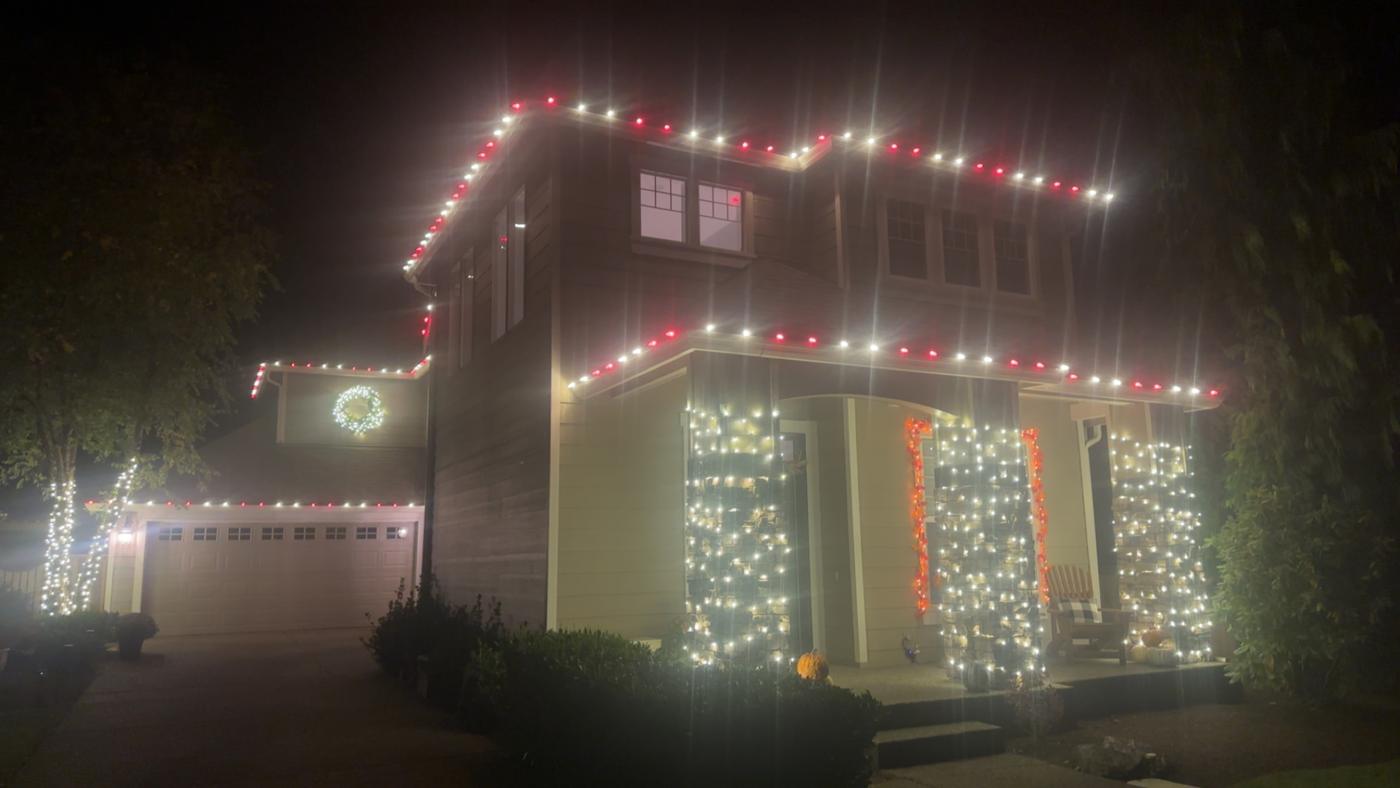 Red and white roofline with lit porch columns and wreath