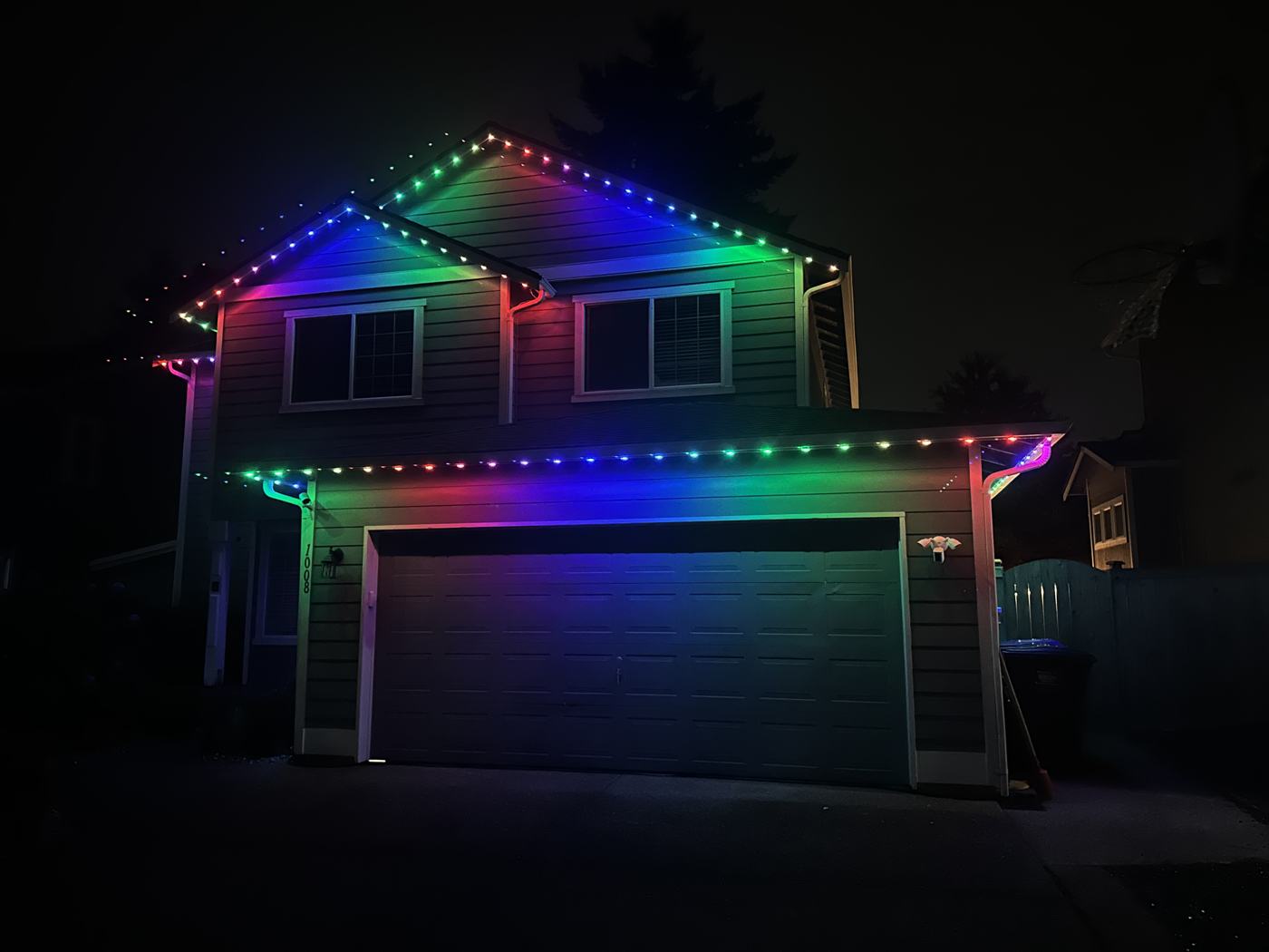 Two-story home with Minleon permanent lights in a rainbow pattern